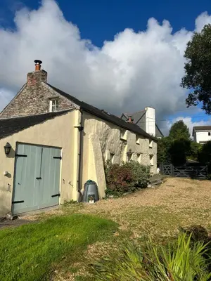 an old house with a green door on the side of it at Meadowside Cottage, Characterful Grade 2 Listed Cottage near to Wadebridge and Padstow in Wadebridge