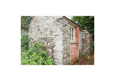 an old brick building with a window on it at Meadowside Cottage, Characterful Grade 2 Listed Cottage near to Wadebridge and Padstow in Wadebridge