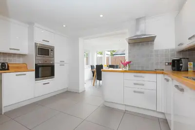 a kitchen with white cabinets and a stove top oven at Carvean in Carbis Bay