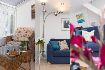 a living room with a blue couch and a table at Carvean in Carbis Bay