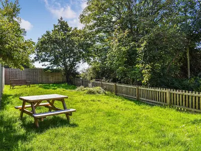 a picnic table in the grass next to a fence at Tarow Cottage in Morval