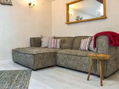 a living room with a couch and a mirror at Tarow Cottage in Morval