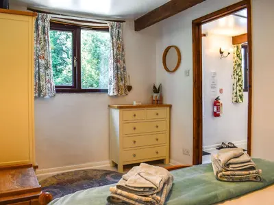 a bedroom with a bed and a dresser and a window at Tarow Cottage in Morval