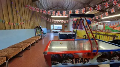 a room with a ping pong table and benches at Roecliff in St Austell