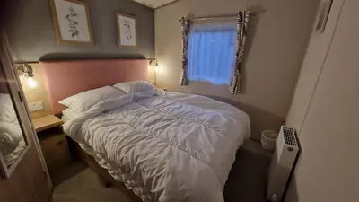 a small bedroom with a bed and a window at Roecliff in St Austell