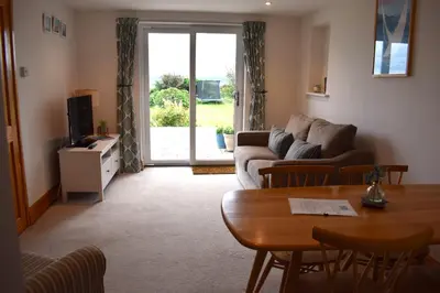 a living room with a couch and a table at The Little House, Wadebridge, Cornwall in Wadebridge