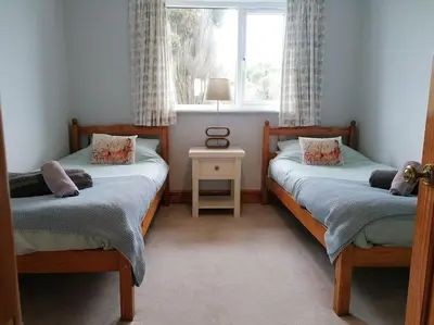 a bedroom with two twin beds and a window at The Little House, Wadebridge, Cornwall in Wadebridge