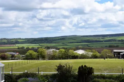 a green field with trees and houses in the distance at The Little House, Wadebridge, Cornwall in Wadebridge