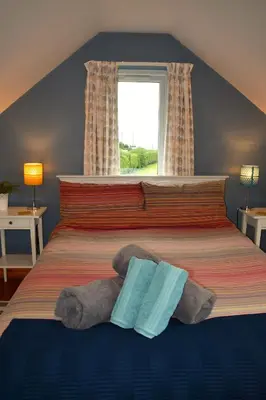 a bedroom with a bed with a stuffed animal on it at The Little House, Wadebridge, Cornwall in Wadebridge