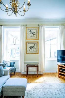 a living room with a couch and two windows at Marazion Beach Town House with Private Parking in Marazion