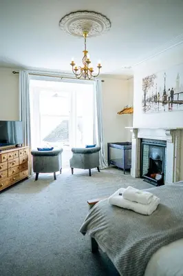 a living room with a bed and a fireplace at Marazion Beach Town House with Private Parking in Marazion