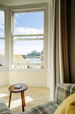 a living room with a large window with a view at Marazion Beach Town House with Private Parking in Marazion