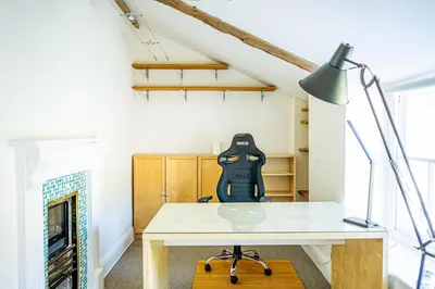a desk in a room with a fireplace at Marazion Beach Town House with Private Parking in Marazion