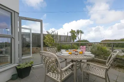 a table and chairs sitting on a balcony with a table and chairsktop at 2 Four Seasons in St Ives