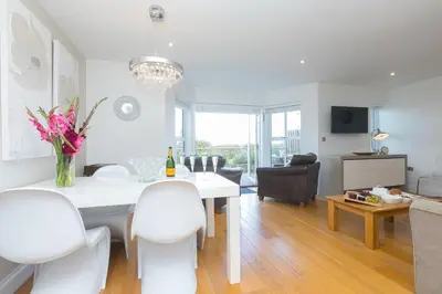 a living room with a white dining room table and chairs at 2 Four Seasons in St Ives