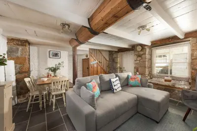 a living room with a couch and a table at Old Arch Cottage, The Digey - 100m From Town & Beach - Free WiFi - 2 Pets Allowed in St Ives