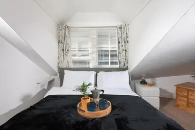 a bedroom with a bed with a tray on it at Old Arch Cottage, The Digey - 100m From Town & Beach - Free WiFi - 2 Pets Allowed in St Ives