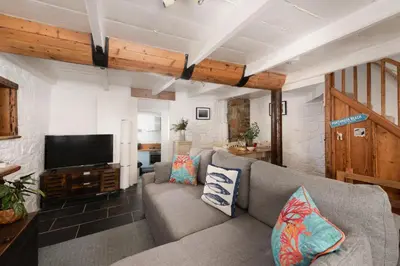 a living room with a couch and a flat screen tv at Old Arch Cottage, The Digey - 100m From Town & Beach - Free WiFi - 2 Pets Allowed in St Ives