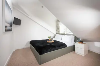 a white bedroom with a bed with a black blanket at Old Arch Cottage, The Digey - 100m From Town & Beach - Free WiFi - 2 Pets Allowed in St Ives
