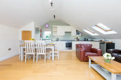 a kitchen and living room with a table and chairs at 7 Sandy Lane in St Ives