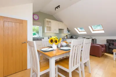 a kitchen and dining room with a table and chairs at 7 Sandy Lane in St Ives