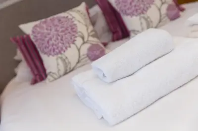 a bed with two towels and pillows on it at 7 Sandy Lane in St Ives