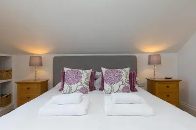 a bedroom with a large white bed with two pillows at 7 Sandy Lane in St Ives