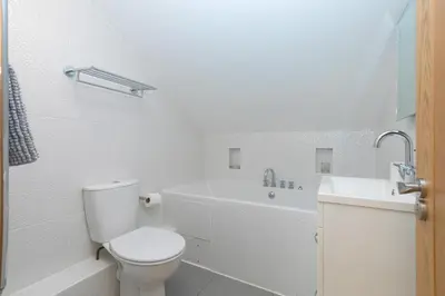 a white bathroom with a toilet and a sink at 7 Sandy Lane in St Ives