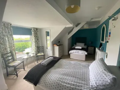 a bedroom with a large bed and a window at Camelot Guest House in Falmouth