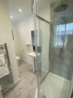 a bathroom with a shower and a sink at Camelot Guest House in Falmouth