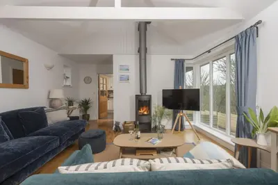 a living room with a blue couch and a tv at Lobbs Cottage, St Mawgan - Free WiFi - Pet Friendly - Free Parking in Saint Mawgan