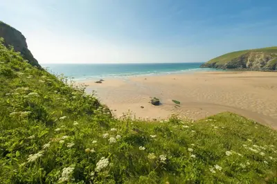 a sandy beach with the ocean in the background at Lobbs Cottage, St Mawgan - Free WiFi - Pet Friendly - Free Parking in Saint Mawgan