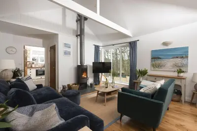 a living room with a blue couch and a tv at Lobbs Cottage, St Mawgan - Free WiFi - Pet Friendly - Free Parking in Saint Mawgan