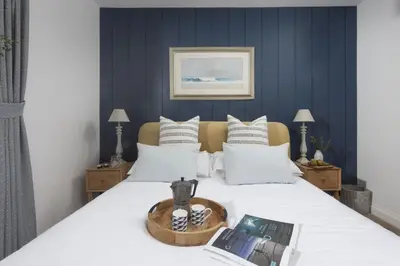 a bedroom with a bed with a book on it at Lobbs Cottage, St Mawgan - Free WiFi - Pet Friendly - Free Parking in Saint Mawgan