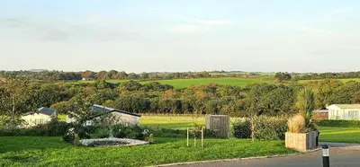 a view of a farm with a field and trees at Hot Tub Lodge Cornwall - Meadow Lakes Holiday Park in St Austell