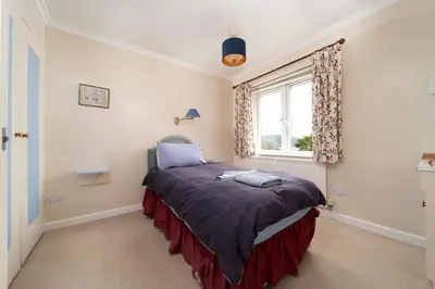 a bed in a room with a window at Seagulls Cottage Cornwall in Saint Mawes