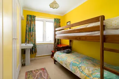 a bedroom with two bunk beds and a sink at Seagulls Cottage Cornwall in Saint Mawes