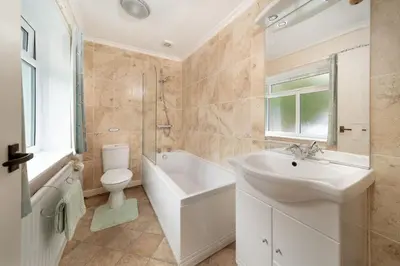 a white bathroom with a sink and a toilet at Seagulls Cottage Cornwall in Saint Mawes