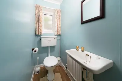 a bathroom with a sink and a toilet and a mirror at Seagulls Cottage Cornwall in Saint Mawes
