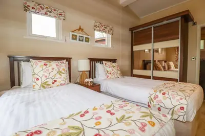 a bedroom with two beds and a mirror at Hideaway Lodge in Tintagel
