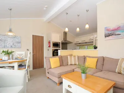 a living room with a couch and a table at Hideaway Lodge in Tintagel