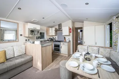a living room with a couch and a table in a caravan at Killigarth Manor Holiday Park in Polperro