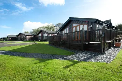 a small cabin in a yard with a grass field at Killigarth Manor Holiday Park in Polperro