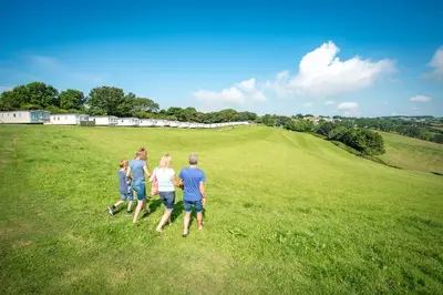 a group of people walking in a field at Killigarth Manor Holiday Park in Polperro