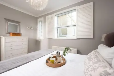 a bedroom with a bed with a tray of food on it at Shearwater View, 7 Rosemorran, St Ives in St Ives
