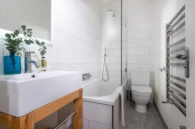 a white bathroom with a sink and a toilet at Shearwater View, 7 Rosemorran, St Ives in St Ives