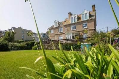 a large house in a yard with green grass at Shearwater View, 7 Rosemorran, St Ives in St Ives