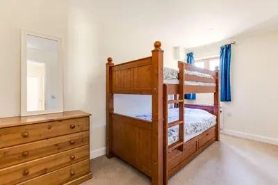 a bedroom with two bunk beds and a dresser at Chy Pol in Wadebridge