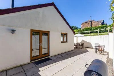 a white house with a patio with tables and chairs at Chy Pol in Wadebridge