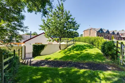 a yard with a fence and green grass at Chy Pol in Wadebridge